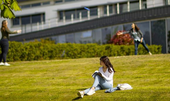 Students playing frisbee on the grass outside , Edinburgh
