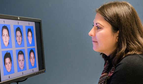  Psychology Student looking at a computer screen displaying 6 different faces numbered 1-6